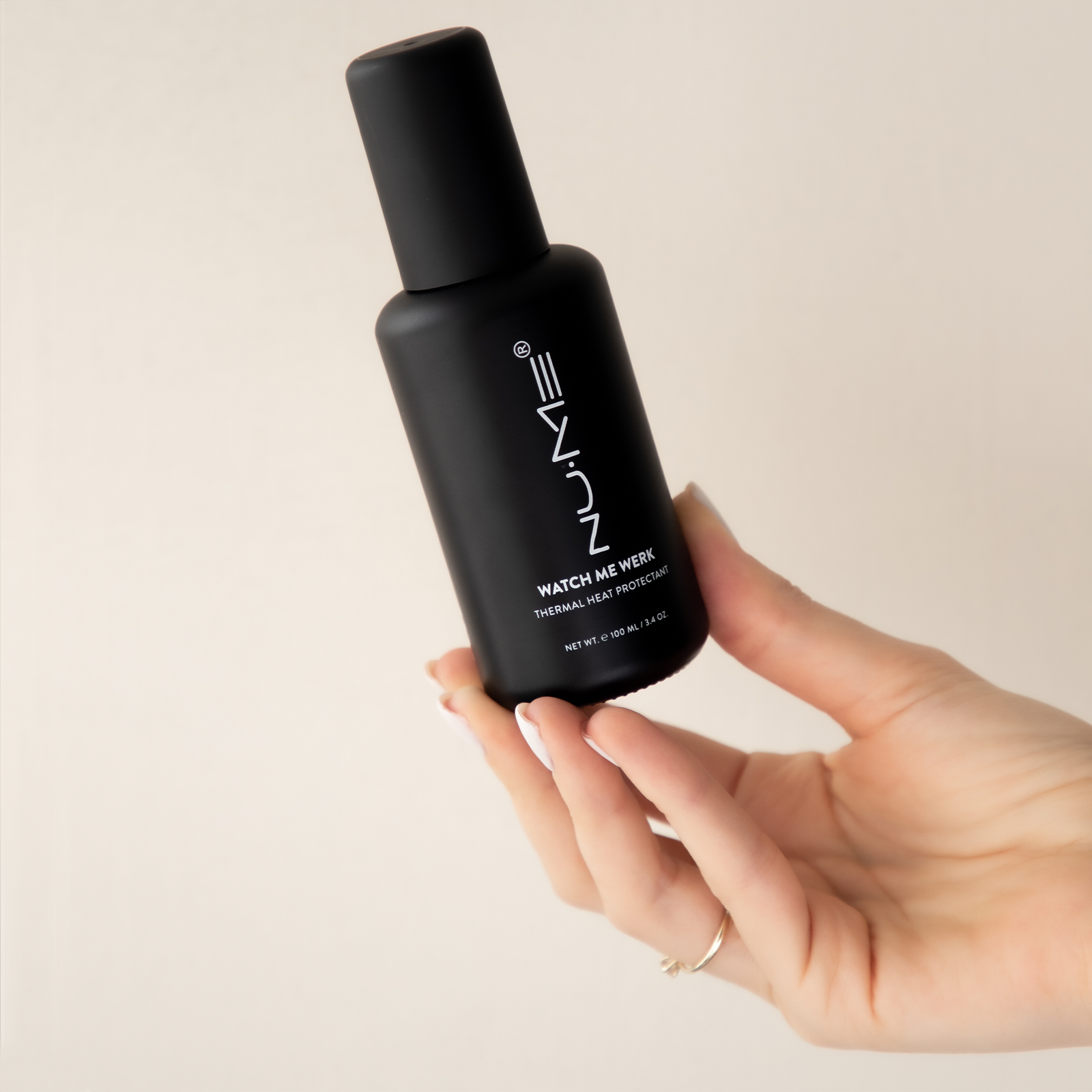 NuMe Watch Me Werk Thermal Heat Protectant in woman's hands